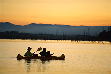 Family canoeing on Lake Tinaroo, a recreation area on the Atherton Tableland in Queensland, Australia, Pacific