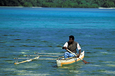 Man in outrigger canoe going to work on the small resort island of Erakor in Erakor Lagoonjust south of the capital, Efate Island, Port Vila, Vanuatu