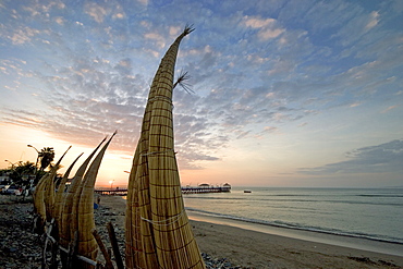 Sunset behind 'caballitos (little horses) de totora' reed boats at the popular far north coast fishing & surfing village of Huanchaco, near Trujillo, Peru, South America.