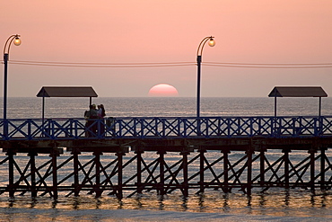 Sunset behind the pier at the popular far north coast fishing & surfing village of Huanchaco, near Trujillo, Peru, South America.