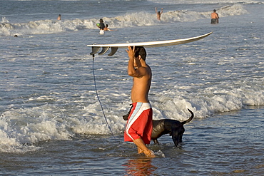 Surfer on the beach at this popular surfing resort in the far north near the Ecuadorean border, Mancora, Peru, South America






