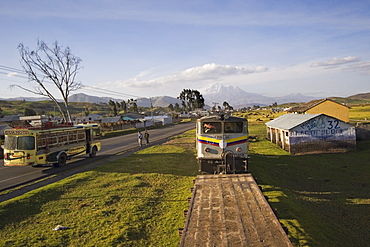 Bus and the famous El Nariz del Diablo (The Devil's Nose) train en route to Riobamba with 6310m Chimborazo volcano in the distance, Riobamba, Chimborazo Province, Central Highlands, Ecuador, South America.