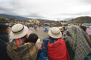 Indigenous women in typical local headgear overlooking the Plaza 15 de Mayo at Carnival time in the provincial town of Guaranda, Bolivar Province, Ecuador, South America