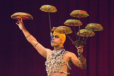 Man performing the Raban Dance and balancing drums in a tourist show at the Kandyan Arts Association Hall, Kandy, Sri Lanka, Asia