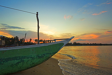 Outrigger boat at sunset at this fishing beach and popular tourist surf destination, Arugam Bay, Eastern Province, Sri Lanka, Asia