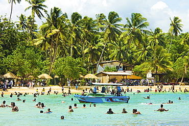 Sri Lankans swimming at the west end of this popular resort and beach, wrecked by the 2004 tsunami, Unawatuna, Galle, Sri Lanka, Asia