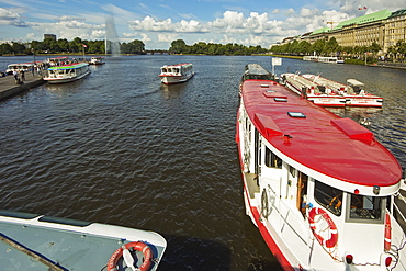 Tour boats that ply the popular Alster Lake moored at the Jungfernstieg with the Ballindamm beyond, Hamburg, Germany, Europe