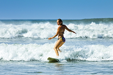 Girl surfing in white water at Playa Guiones beach, Nosara, Nicoya Peninsula, Guanacaste Province, Costa Rica, Central America