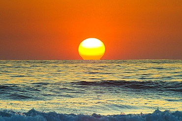 Sun touching horizon at sunset, Playa Guiones beach, Nosara, Nicoya Peninsula, Guanacaste Province, Costa Rica, Central America