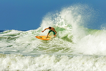 Surfer on shortboard riding wave at popular Playa Guiones surf beach, Nosara, Nicoya Peninsula, Guanacaste Province, Costa Rica, Central America