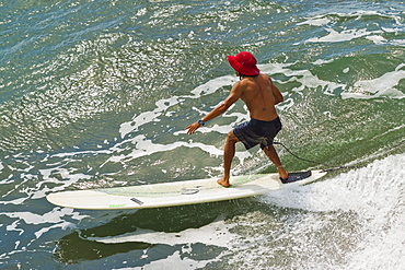 Surfer on a wave at this popular point break surf spot and small resort, Batu Karas, near Pangandaran, West Java, Java, Indonesia, Southeast Asia, Asia