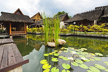 Traditional kampung style rooms over carp ponds at the Kampung Sumber Alam hot springs hotel, Garut, West Java, Java, Indonesia, Southeast Asia, Asia