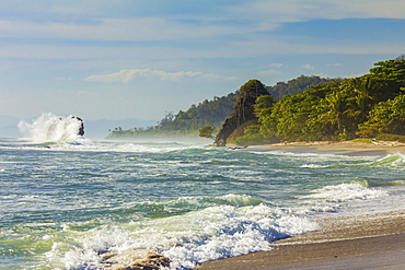 Surf breaking on sea stack and the Penon rock at this far south Nicoya Peninsula beach, Santa Teresa, Puntarenas, Costa Rica, Central America