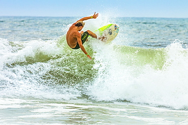 Shortboard surfer riding a wave at this surf resort on the south coast of Nicoya Peninsula, Santa Teresa, Puntarenas, Costa Rica, Central America