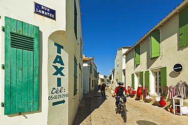 Cyclist on Rue Lamathe in the island's principal western town, Ars en Re, Ile de Re, Charente-Maritime, France, Europe