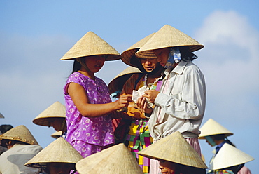 Women in conical hats counting money at the fish market by the Thu Bon River in Hoi An, south of Danang, Vietnam, Indochina, Asia