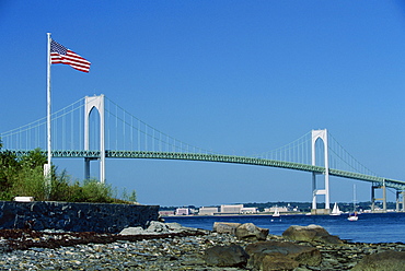 The Stars and Stripes flying before the Newport Bridge, connecting Jamestown, Conanicut Island, and Aquidneck Island, Rhode Island, New England, United States of America, North America