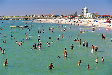 Groups of people in the sea and on the beach at Glenelg, a resort suburb of Adelaide, where first South Australian colonists landed, South Australia, Australia, Pacific