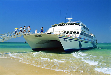 Tourists boarding large catamaran on beach near Rockhampton, Queensland, Australia, Pacific