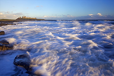 Surf on rocks, Dunstanburgh Castle, Northumberland, England, United Kingdom, Europe 