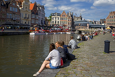 Young people enjoy summer sunshine along the Graslei and Korenlei, Ghent, Belgium, Europe