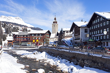 Hotel Krone, river and village church, Lech near St. Anton am Arlberg in winter snow, Austrian Alps, Austria, Europe