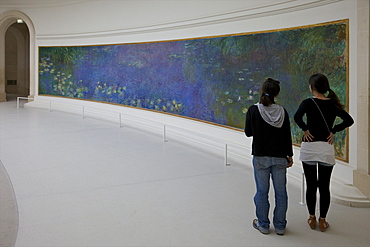 Two young women admire the Water-lilies by Claude Monet, Musee de L'Orangerie Museum, Paris, France, Europe