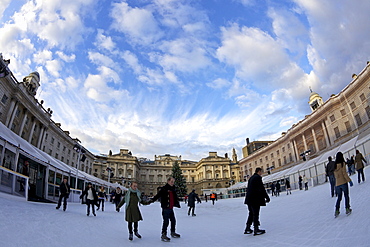 Skaters skating on outside ice rink, Somerset House, London, England, United Kingdom, Europe