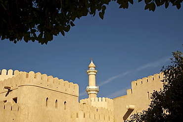 View of the fort of Nizwa, with the minaret of the Sultan Quaboos Mosque, Oman, Middle East