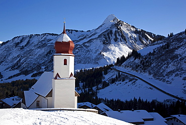 St. Nicholas, little church of Damuels with traditional bulb roof, mountains at back, Vorarlberg, Austria, Europe