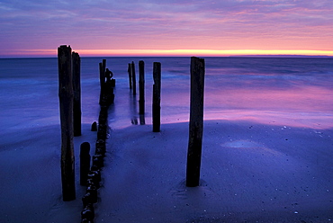 Beach with stakes in Juliusruh at sunrise and view on the Tromper Wiek bay, Baltic Sea, Ruegen island, Mecklenburg-Western Pomerania, Germany, Europe