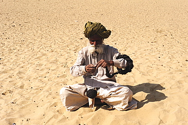 Old man spinning wool with a hand spindle, Thar Desert, Rajasthan, North India, India, Asia