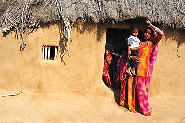 Woman in a sari with a toddler at the entrance to her house, Thar Desert, Rajasthan, North India, India, Asia