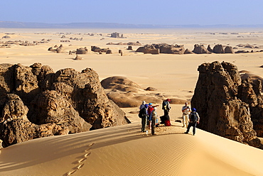 Group of tourists, hikers in the sandstone rock formation of Tin Akachaker, Tassili du Hoggar, Wilaya Tamanrasset, Algeria, Sahara desert, North Africa