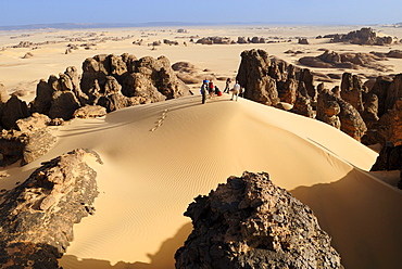 Group of tourists, hikers in the sandstone rock formation of Tin Akachaker, Tassili du Hoggar, Wilaya Tamanrasset, Algeria, Sahara desert, North Africa