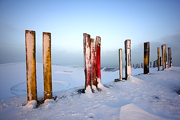 "Totems" landmark art installation created from more than 100 processed railway sleepers by Basque painter and sculptor Agustin Ibarrola, situated on snow-covered mining waste heap Halde Haniel above the pit Prosper-Haniel in winter, Bottrop, North Rhine-