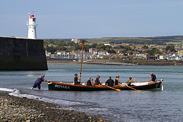 Cornish pilot gig rowing boat entering the water, Newlyn, Cornwall, England, United Kingdom, Europe