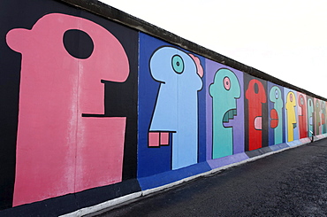 Colorful heads in comic-style, painting on the remants of the Berlin Wall, East Side Gallery, Friedrichshain district, Berlin, Germany, Europe