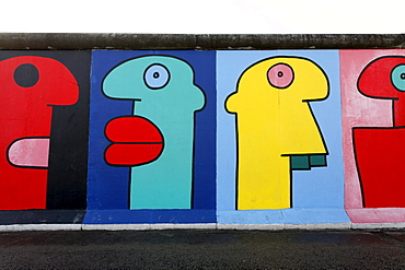 Colorful heads in comic-style, painting on the remants of the Berlin Wall, East Side Gallery, Friedrichshain district, Berlin, Germany, Europe