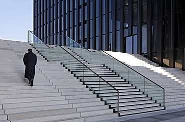 Businessman climbing a flight of stairs next to a tower building, Hafenspitze, Medienhafen harbour, Duesseldorf, North Rhine-Westphalia, Germany, Europe