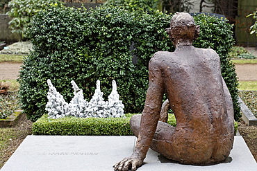 Male figure sitting on a grave stone, modern grave sculpture, Nordfriedhof Cemetery, Duesseldorf, North Rhine-Westphalia, Germany, Europe