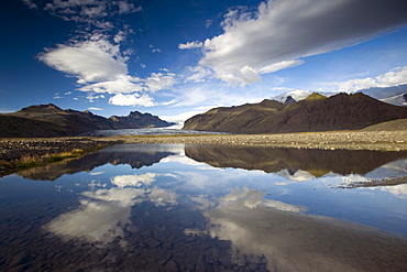 Clouds reflected in the Skafta glacial river, Skaftafell, Vatnajoekull National Park, South Iceland, Europe