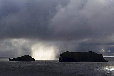 Sunlit rain between two Westman Islands or Vestmannaeyjar, South Iceland, Europe