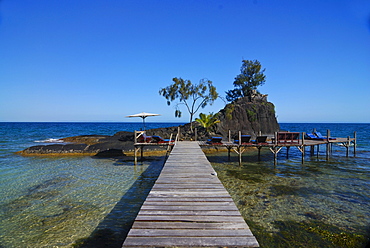 Jetty leading to a small rocky island with sunbeds, Santa Maria island, Madagascar, Africa