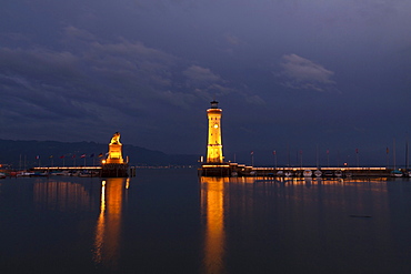 Lighthouse and the Bavarian lion, symbol of the city, at the harbour entrance of Lindau on Lake Constance, Bavaria, Germany, Europe