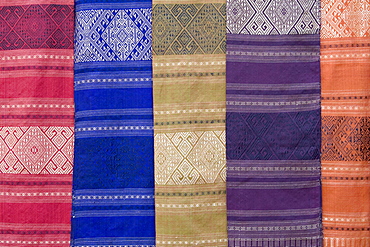 Colourful silk textiles on display at a market stall in Luang Prabang, Laos, Southeast Asia