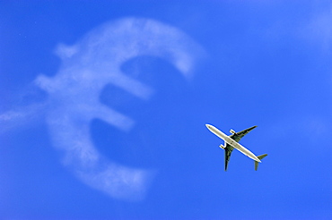 Aircraft flying against a blue sky with a Euro sign, symbolic image for aviation tax