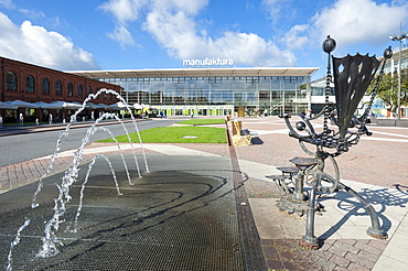 Fountains and chair sculpture in front of Manufaktura Shopping Centre, Lodz, Poland, Europe