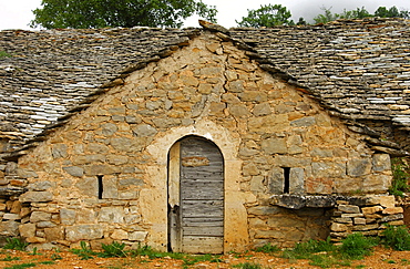 Wooden door to an abandoned semi troglodyte wine cellar with natural stone roof in Entre-deux-Monts at Riviere-sur-Tarn, Aveyron, France, Europe