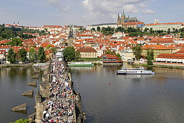 View from the Old Town Bridge Tower looking towards the Vltava river, Charles Bridge with tourists, Hradschin castle district and St Vitus Cathedral, Prague, Czech Republic, Europe